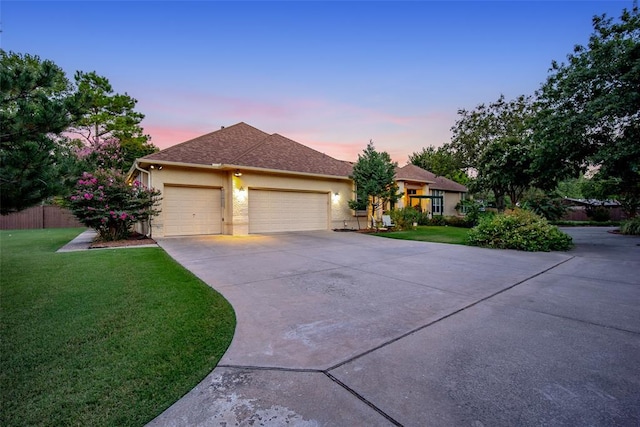 single story home featuring a lawn, fence, an attached garage, and driveway