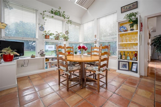 dining space with high vaulted ceiling