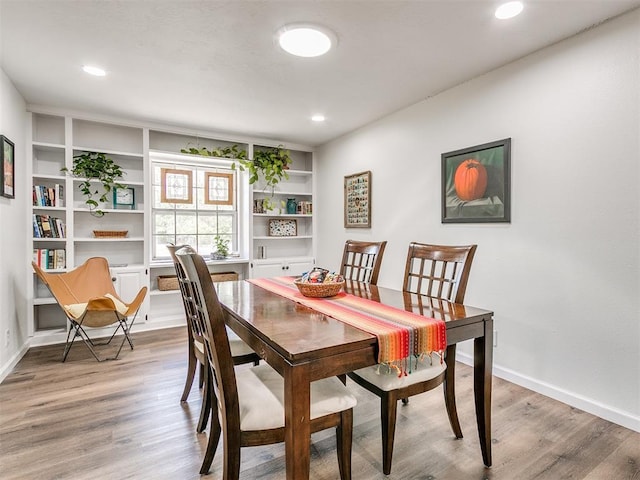 dining space with built in features, baseboards, recessed lighting, and wood finished floors