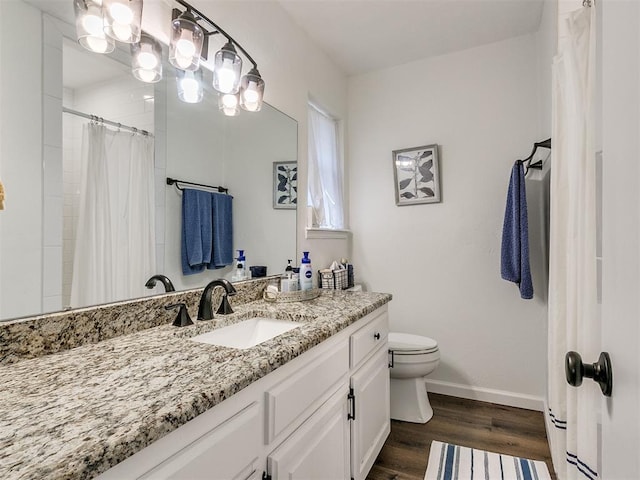 bathroom featuring a shower with curtain, wood finished floors, baseboards, vanity, and toilet