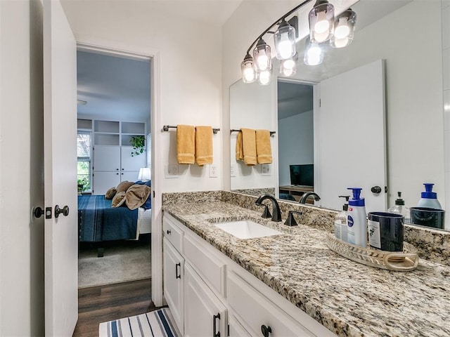 bathroom featuring wood finished floors, ensuite bathroom, and vanity
