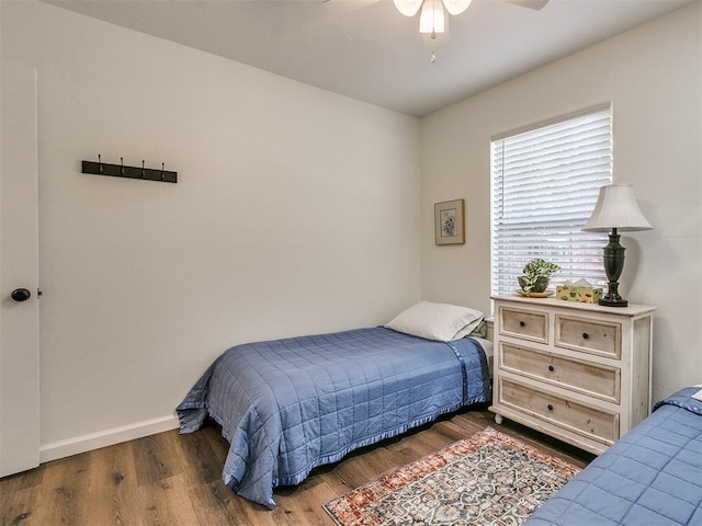 bedroom with baseboards, a ceiling fan, and wood finished floors