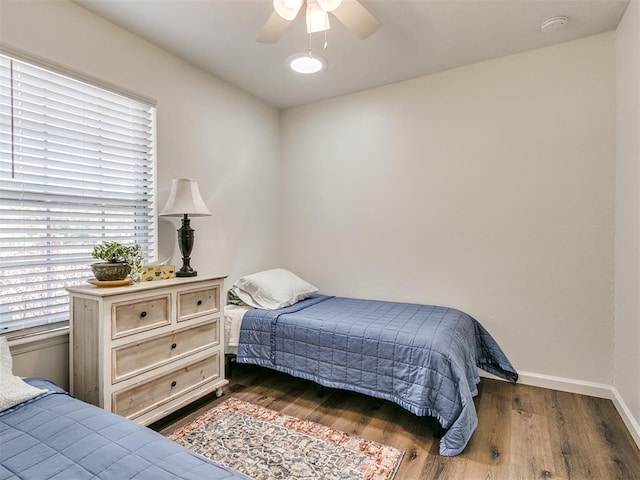 bedroom with baseboards, a ceiling fan, and wood finished floors