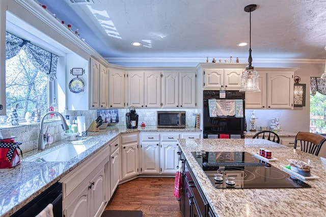 kitchen featuring dark wood-style flooring, a sink, decorative light fixtures, backsplash, and black appliances