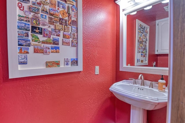bathroom with a textured wall and a sink