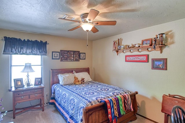 carpeted bedroom with a ceiling fan, baseboards, and a textured ceiling