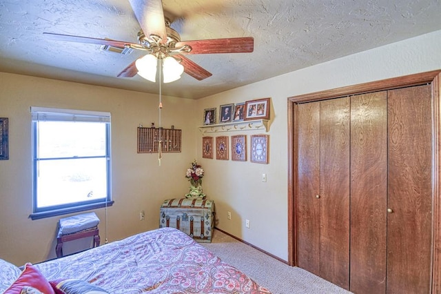 carpeted bedroom with a closet, ceiling fan, and visible vents