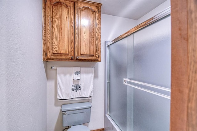 full bathroom featuring toilet and a textured wall