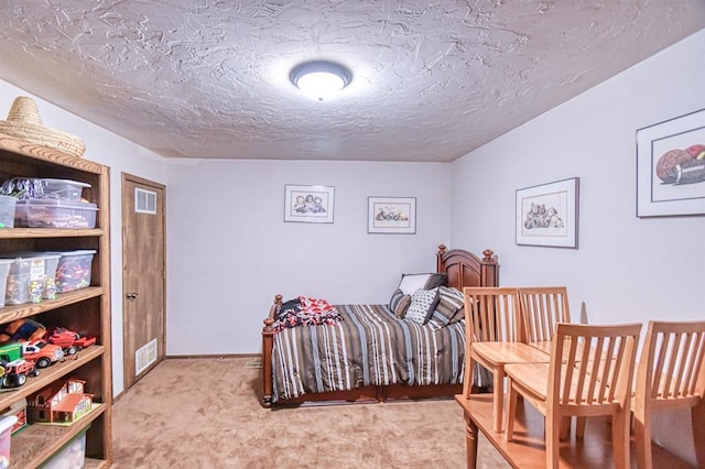 bedroom with carpet flooring, a textured ceiling, visible vents, and baseboards