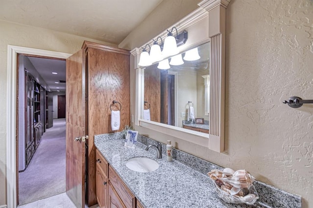 bathroom featuring a textured wall and vanity