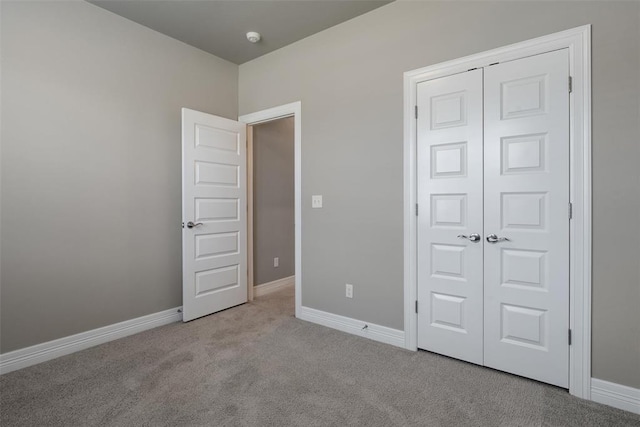unfurnished bedroom featuring baseboards, a closet, and carpet