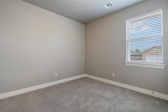 carpeted spare room with baseboards and visible vents