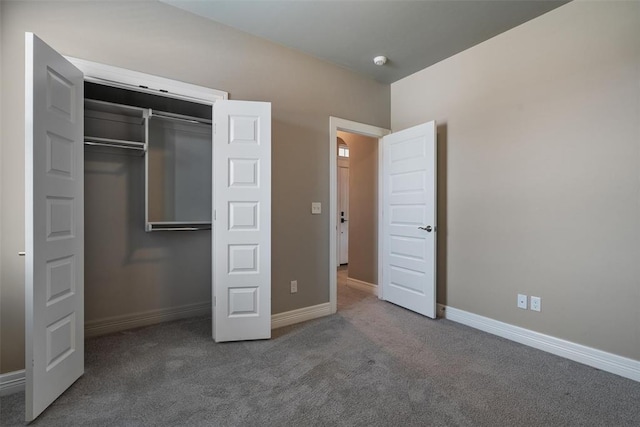 unfurnished bedroom with baseboards, carpet floors, and a closet