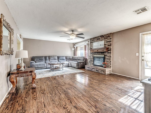 living area featuring a textured ceiling, visible vents, ceiling fan, and a healthy amount of sunlight