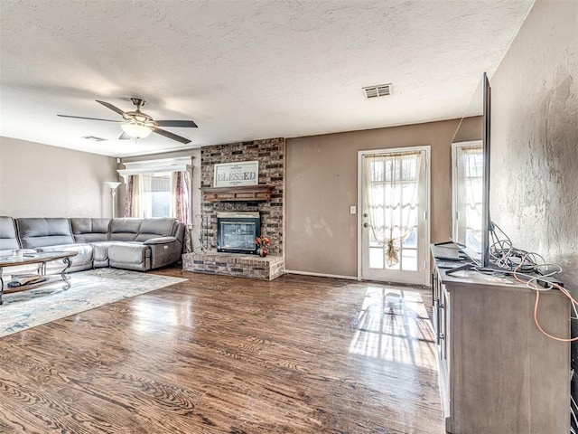 living room with wood finished floors, a textured ceiling, ceiling fan, and plenty of natural light