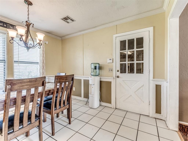 dining space with crown molding, a chandelier, visible vents, and light tile patterned floors