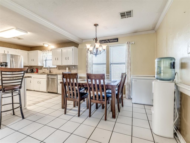 dining room with a chandelier, visible vents, crown molding, and light tile patterned floors