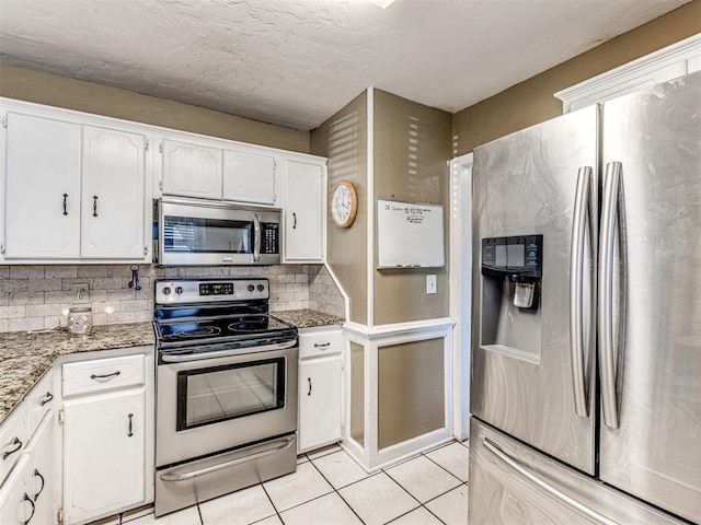 kitchen featuring white cabinets, light tile patterned flooring, tasteful backsplash, and stainless steel appliances