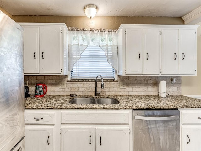 kitchen featuring decorative backsplash, white cabinetry, stainless steel appliances, and a sink