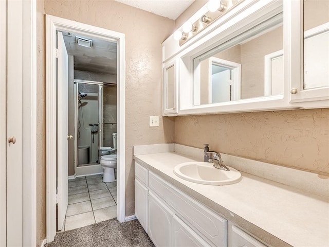 full bathroom featuring tile patterned floors, visible vents, toilet, vanity, and a stall shower