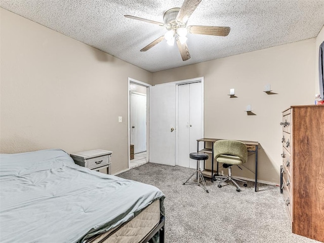 bedroom featuring a ceiling fan, carpet floors, a closet, baseboards, and a textured ceiling