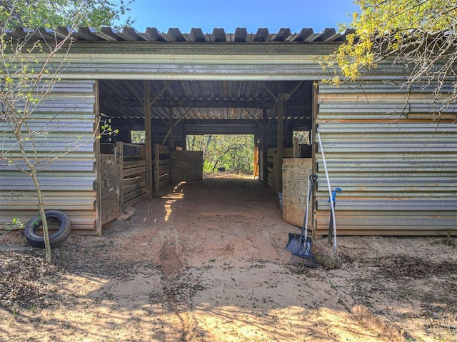 view of parking / parking lot with a carport and an exterior structure