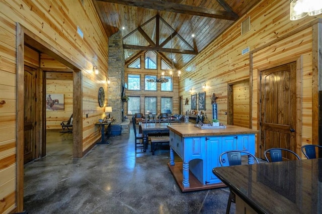 312 Sugar Pine Loop, Broken Bow, OK 74728 - kitchen with an inviting chandelier, butcher block counters, wood walls, finished concrete floors, and high vaulted ceiling