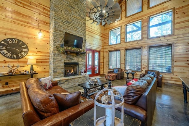 312 Sugar Pine Loop, Broken Bow, OK 74728 - living area featuring wood walls, a towering ceiling, a fireplace, and finished concrete flooring