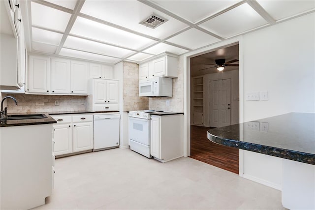 kitchen featuring a sink, white appliances, tasteful backsplash, visible vents, and dark countertops