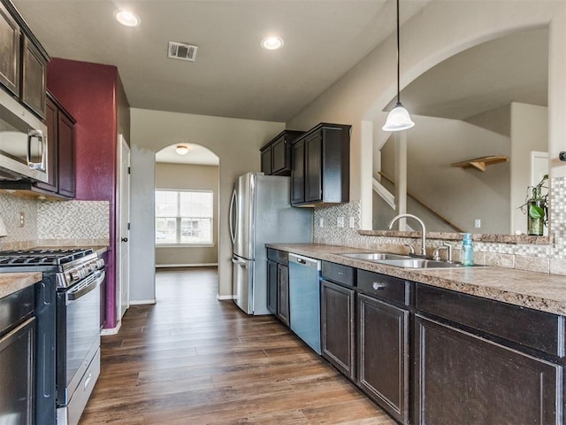 13309 Beaumont Dr, Piedmont, OK 73078 - kitchen featuring visible vents, a sink, light countertops, arched walkways, and appliances with stainless steel finishes