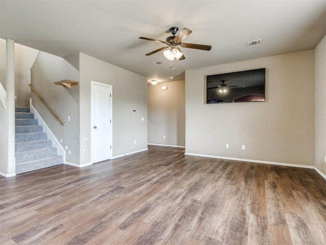 13309 Beaumont Dr, Piedmont, OK 73078 - unfurnished living room featuring visible vents, wood finished floors, baseboards, ceiling fan, and stairway