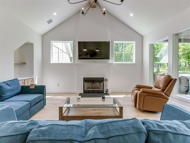 8241 Red Feather, Arcadia, OK 73007 - living area featuring a large fireplace, visible vents, wood finished floors, and a wealth of natural light