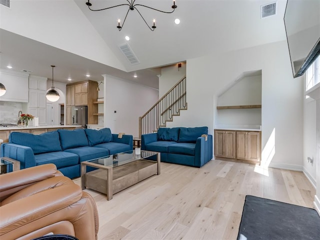 8241 Red Feather, Arcadia, OK 73007 - living area featuring visible vents, light wood finished floors, a notable chandelier, and high vaulted ceiling