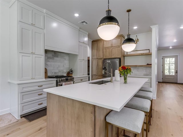 8241 Red Feather, Arcadia, OK 73007 - kitchen with visible vents, appliances with stainless steel finishes, open shelves, a sink, and light wood-style flooring