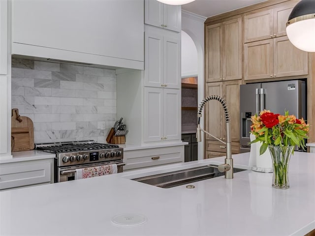 8241 Red Feather, Arcadia, OK 73007 - kitchen with a sink, light countertops, arched walkways, stainless steel appliances, and backsplash