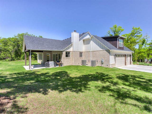 8241 Red Feather, Arcadia, OK 73007 - back of property featuring driveway, a chimney, central AC unit, brick siding, and a yard