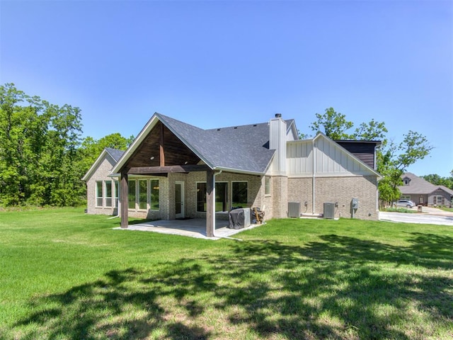 8241 Red Feather, Arcadia, OK 73007 - rear view of house featuring a lawn, brick siding, cooling unit, and a patio