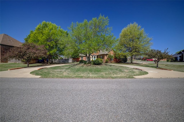 view of front of home with fence, driveway, and a front yard
