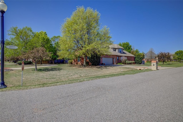 view of front of home with fence, a front yard, and a garage