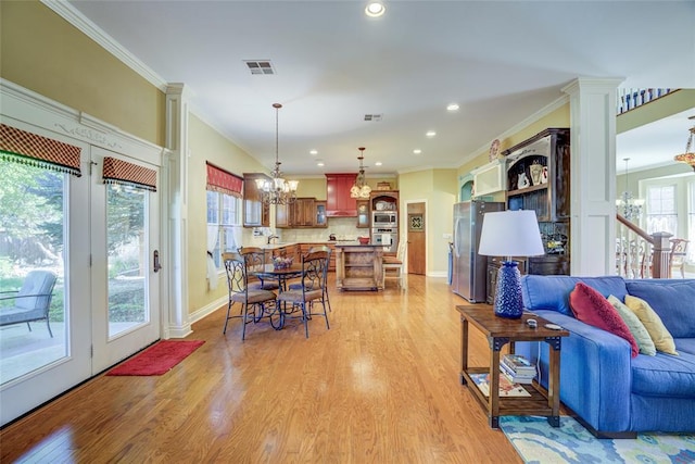 living area with light wood finished floors, visible vents, recessed lighting, a chandelier, and crown molding