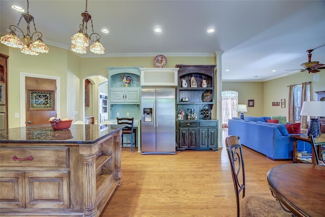 kitchen with open shelves, light wood-style floors, arched walkways, stainless steel refrigerator with ice dispenser, and ornamental molding