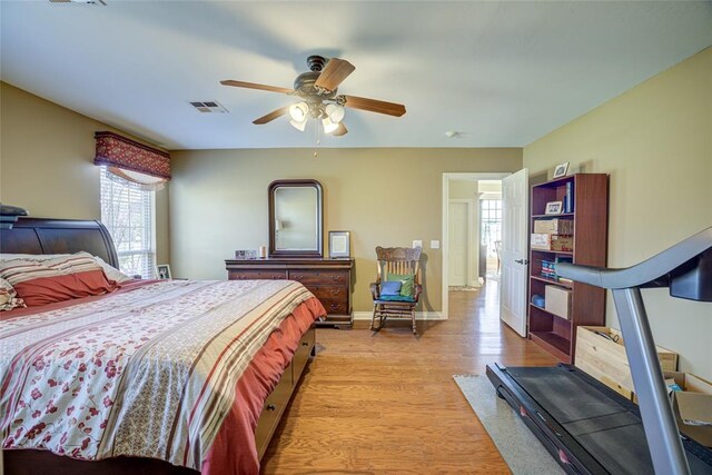 bedroom with baseboards, light wood-style flooring, visible vents, and multiple windows