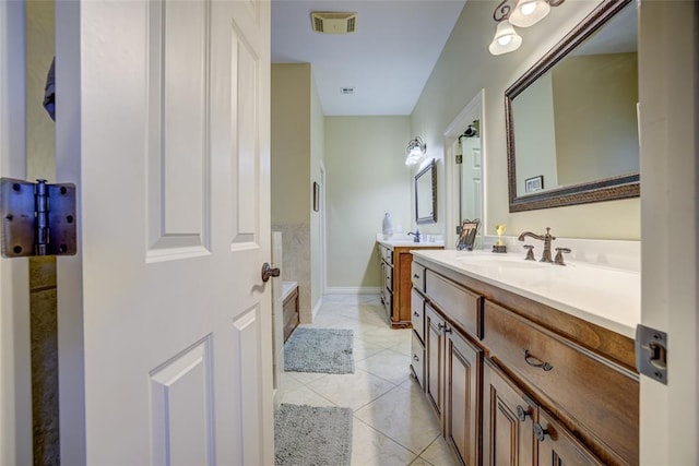 bathroom featuring two vanities, tile patterned flooring, a sink, and a bathtub
