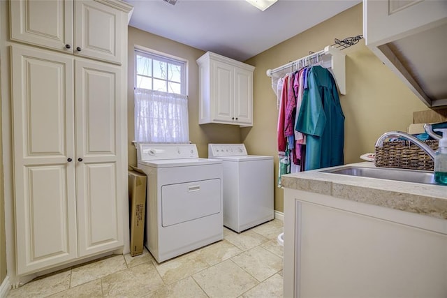 laundry area with washing machine and clothes dryer, baseboards, a sink, and cabinet space