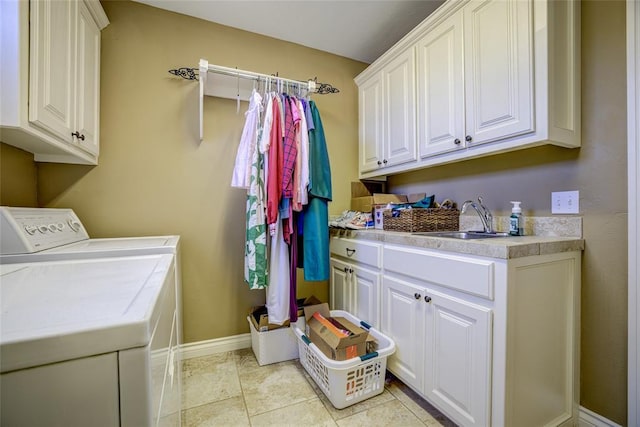 laundry area with washing machine and dryer, baseboards, cabinet space, and a sink