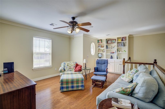 living area with wood finished floors, visible vents, crown molding, baseboards, and ceiling fan