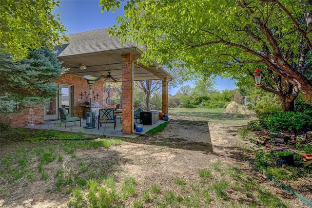 view of yard featuring a patio area and a ceiling fan