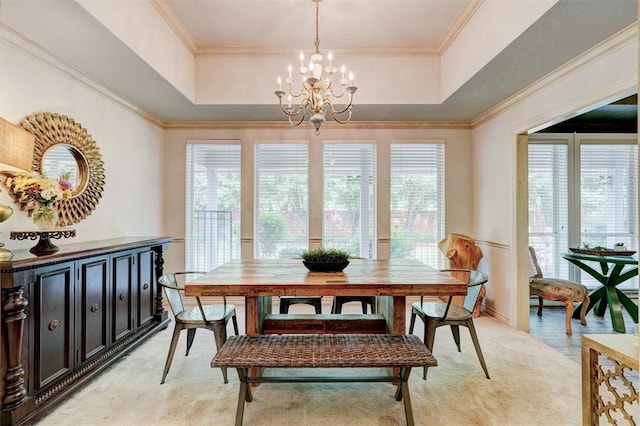 dining room featuring an inviting chandelier, a raised ceiling, and a wealth of natural light