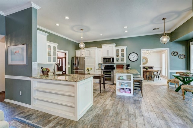 kitchen featuring open shelves, a sink, stainless steel appliances, a peninsula, and visible vents