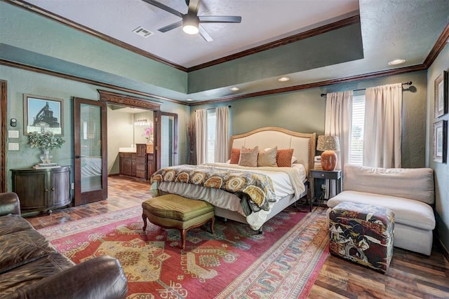 bedroom with visible vents, ornamental molding, wood finished floors, and multiple windows